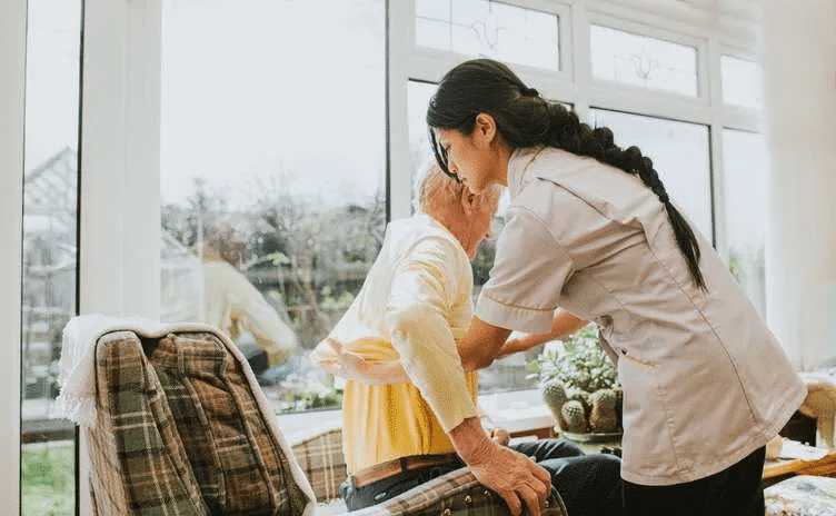 Care assistant helps senior